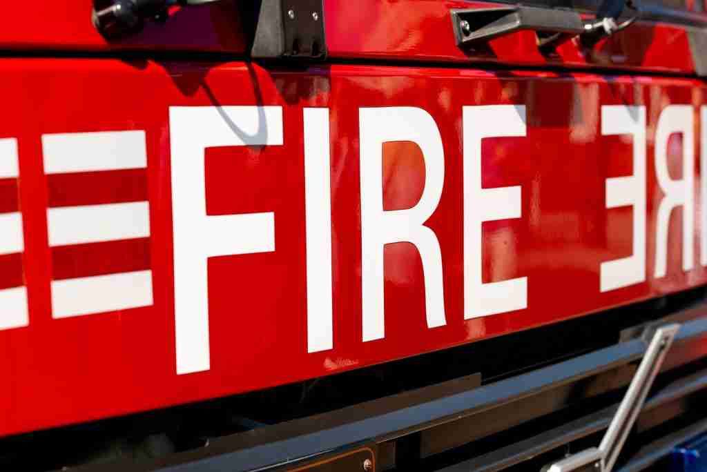Fire written on front of fire engine close up.