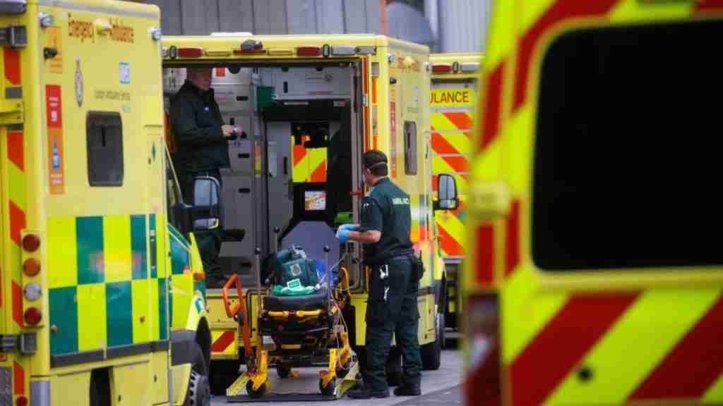 Paramedics in rear of ambulance with other ambulances shown