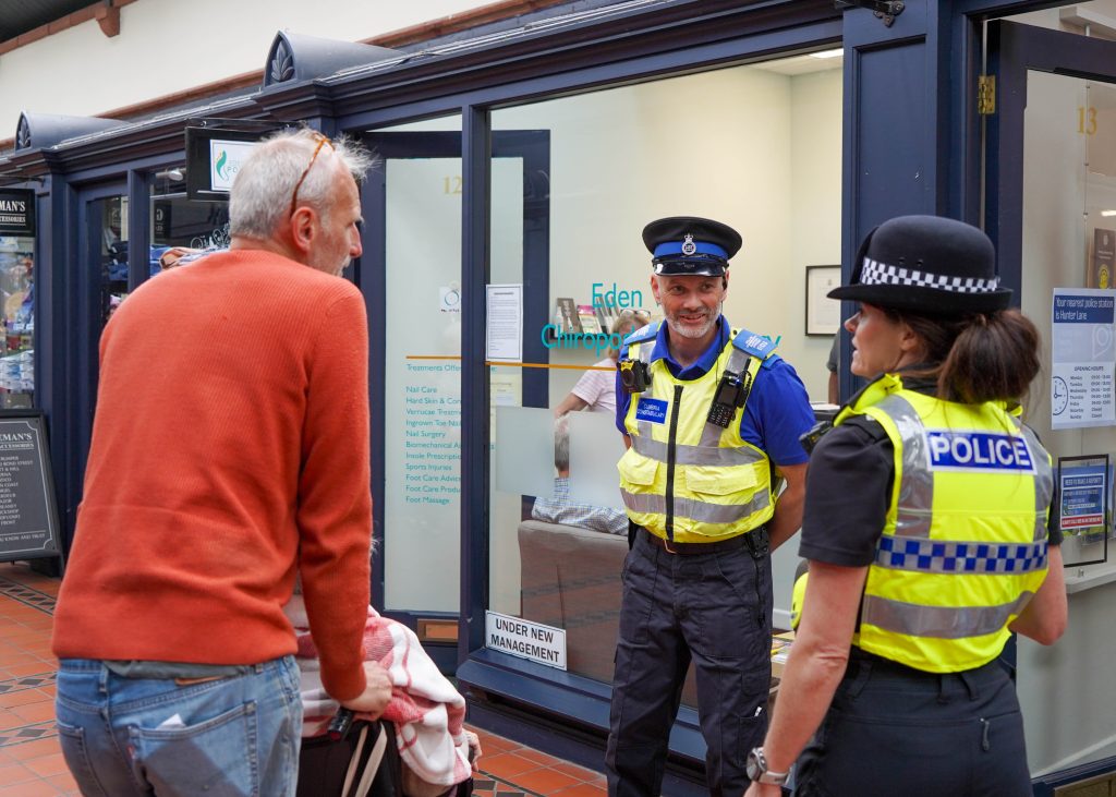 Cumbria Police officers talking to member of the public in town centre