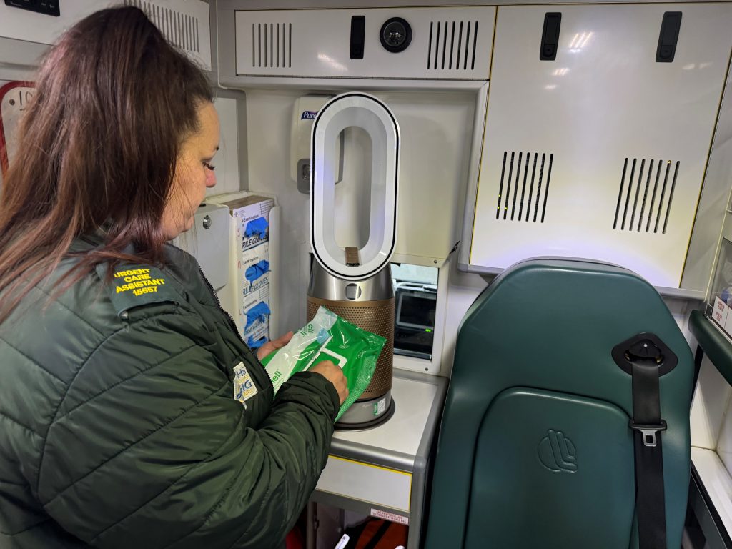 Paramedic in back of ambulance with fan in operation
