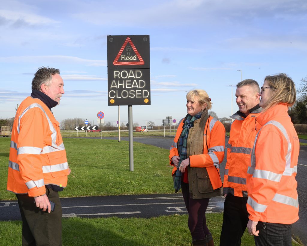 Officials from North Yorkshire Council with a flood warning sign at Bedale bypass roundabout