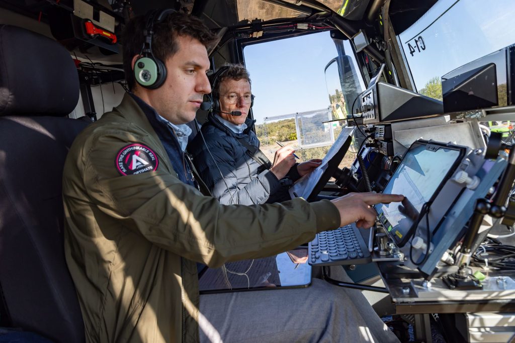Two male operators using the Airbus control wildfire system while sitting in the cab of a vehicle.